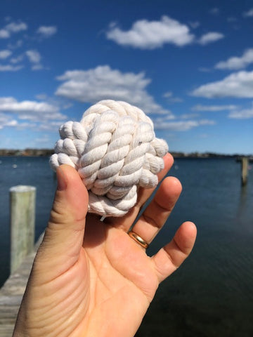 a monkey fist knot held over the Mystic River