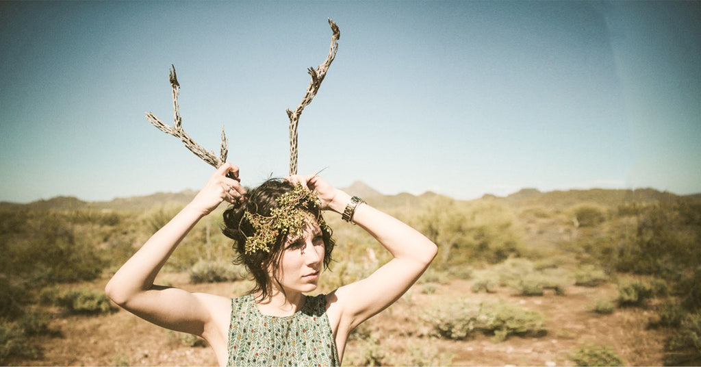 Woman in desert playing with cholla branches on her head