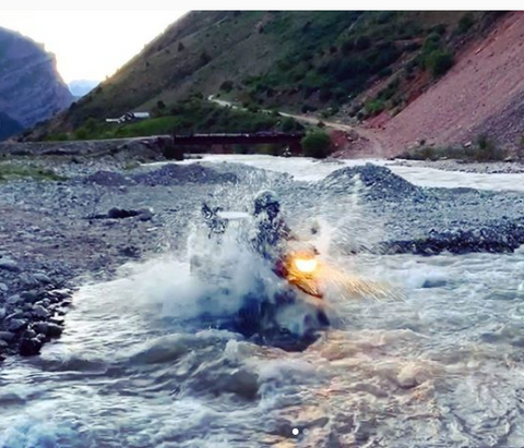 The author crossing a river in Tajikistan