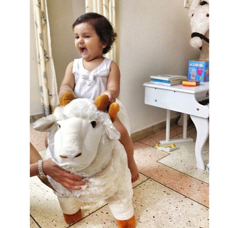 baby girl on a giant merino sheep