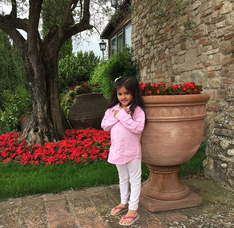 tuscan umbrian countryside with baby girl toddler in front of huge italian planter