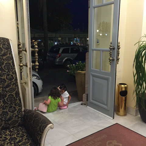 Two little girls saying good bye at Grande Bretagne Hotel, Nafplion greece. Jazz era town with little friendships, one world, vacation, travel, love.