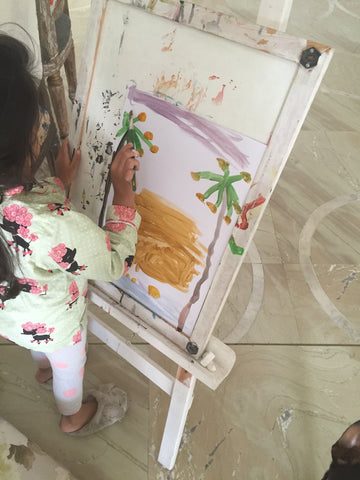 Baby painting art on an easel