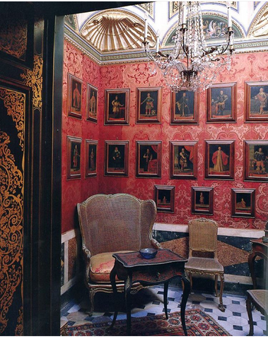 small red wall papered reading room with frames and french louis xv chairs