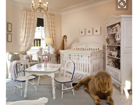 beautiful baby nursery with classic decor and oversized toys. 