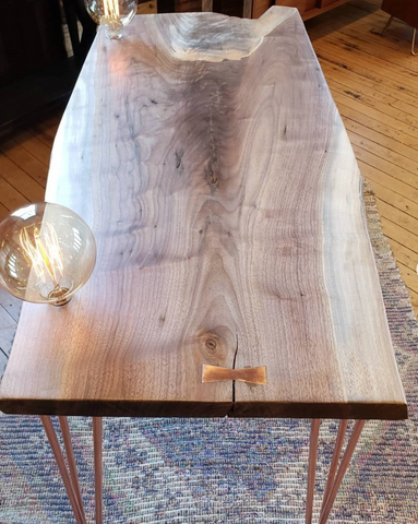 Walnut table with copper hairpins and Edison lights