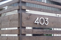 modern house numbers on wood fence 403