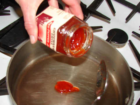 photo of adding red pepper jelly to a sauce pan