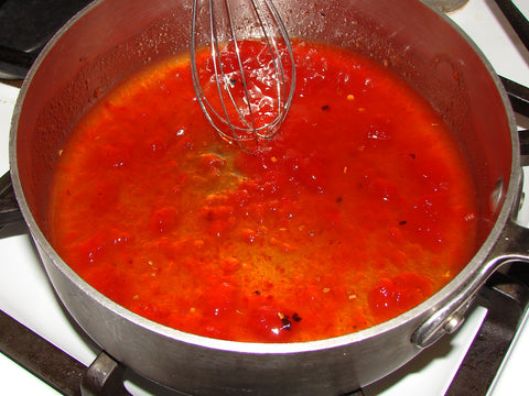 photo of red pepper jelly dipping sauce in pan with whisk