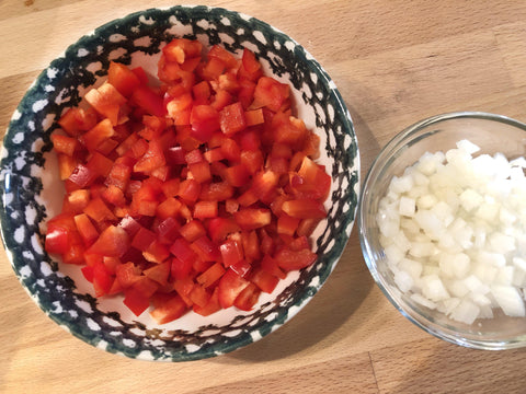 up close photo of chopped red bell peppers and diced white onion