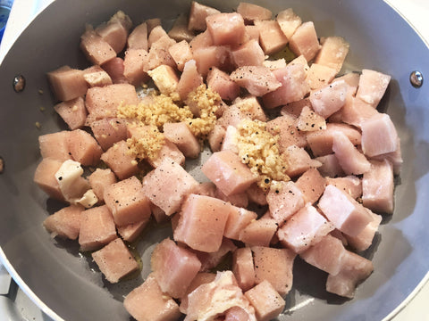 photo of diced chicken breast in pan with garlic