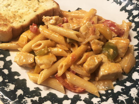 up close photo of cooked fajita pasta on plate with garlic bread