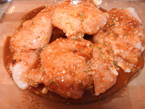 up close photo of marinating chicken breasts 