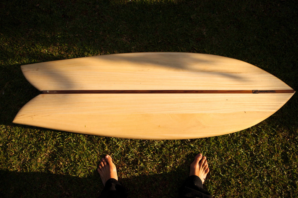 Wooden surfboard lying on the grass