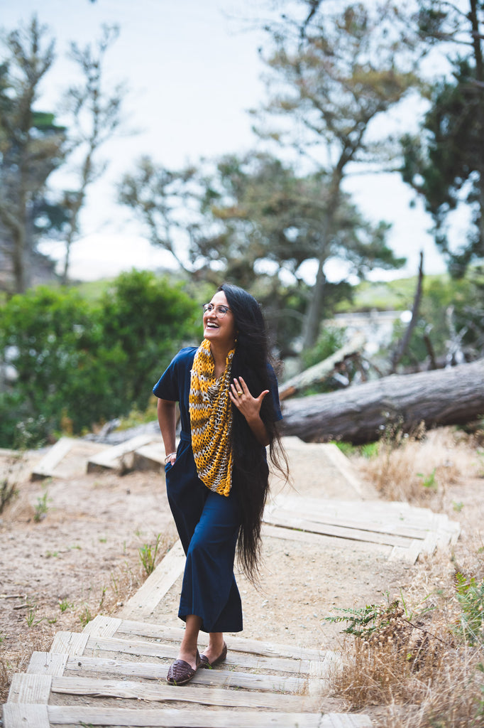 Manpreet Kalra wearing a navy blue jump suit and handknit mustard colored poncho