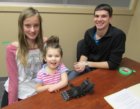 Student working to 3D print a prosthetic hand for a small girl