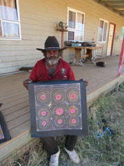 George Petyarre holding square dot painting