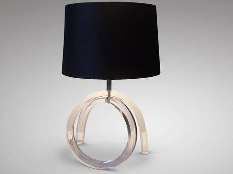 A distinctive 1970s Lucite table lamp with translucent curved lines elegantly contrasting with a powerful, deep black shade. 