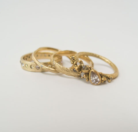Four gold wedding rings with diamonds made by designers Rebecca Overmann and Ruth Tomlinson—all of which can be customized to your liking.