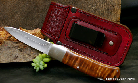 3.5" folding pocket knife showing reverse side and metal belt clip of handmade leather sheath