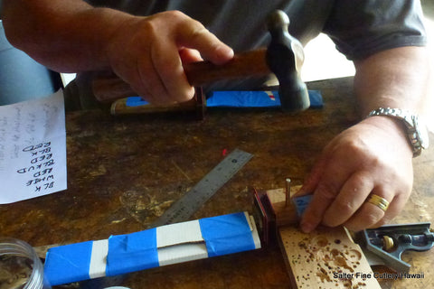 Adding the pins to a knife. All work is done by hand. 