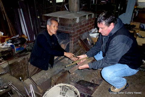 Gregg and master Japanese blade maker at his forge showing us our knives he has just made