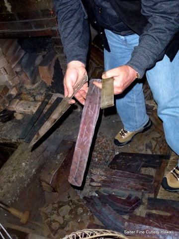 Gregg showing steel bar used to make our blades together with a semi-completed knife at the shop of one of our bladesmiths in Japan