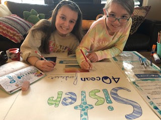 Olivia and Julia Creating a sign to support the Sister 4ocean Fundraiser
