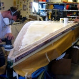 Sanding Sandra during the boat restoration project.