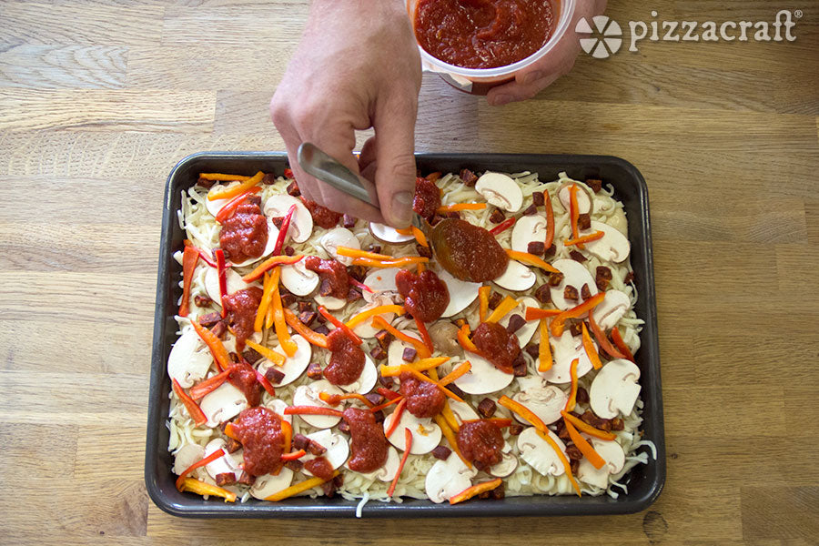 Add Spoonfuls of Pizza Sauce to the Pizza