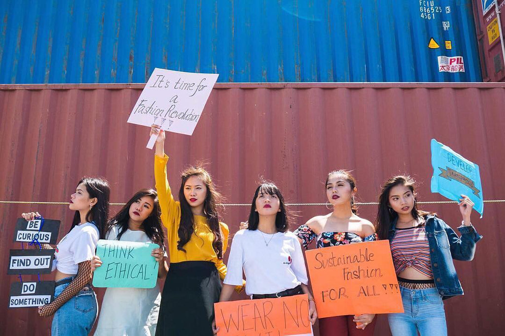 A group of college students defiantly hold up signs in protest against fast fashion in Philippines