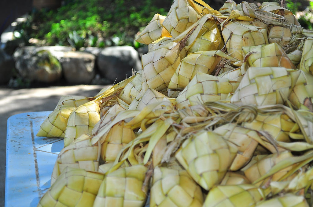 A large pile of puso, rice wrapped in woven palm leaves, to make religious offerings in the Philippines.