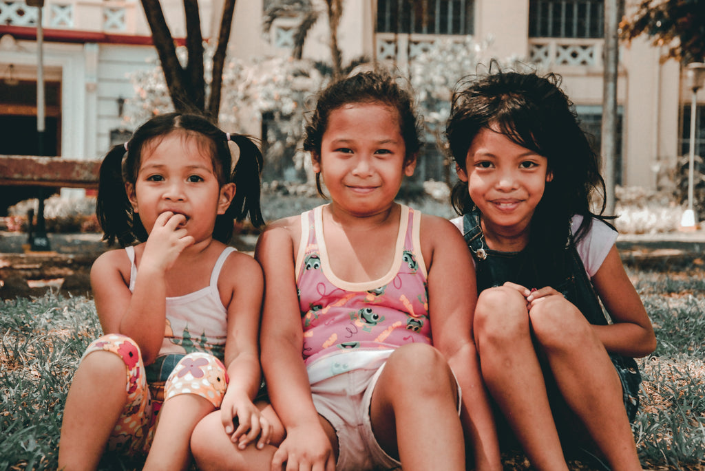 Three Filipina children sitting and hanging out