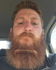 man with milkman beard comb in beard