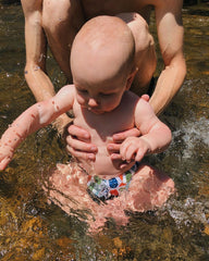 Baby wearing reusable swim diaper enjoying the water