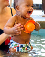 Baby wearing reusable swim diaper enjoying the pool