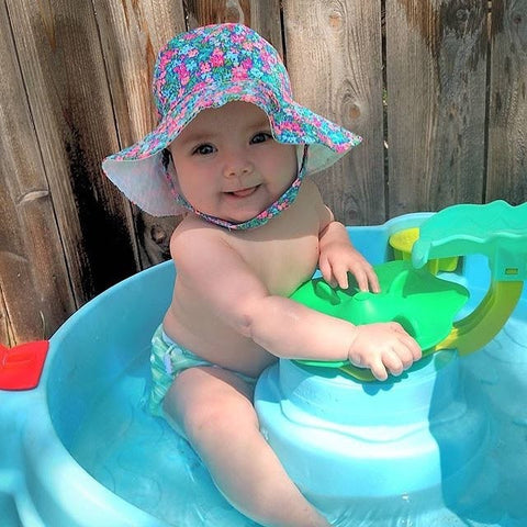 Baby wearing hat and reusable swim diaper