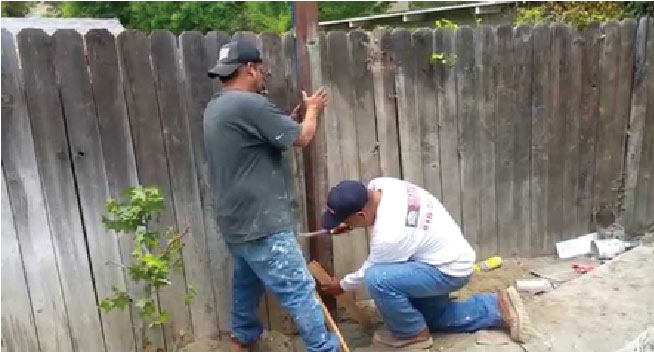 People showing how to fix a wood fence