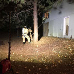 LED generator-light in the foreground lighting firefighters in the background.