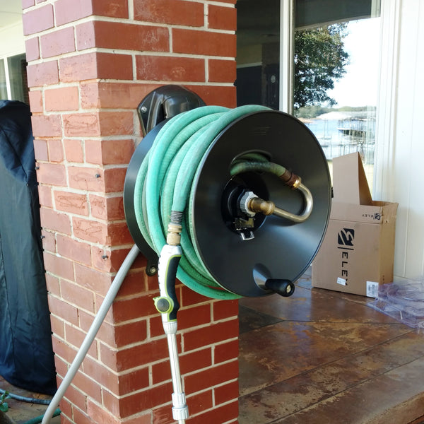 garden hose reel mounted to a brick column