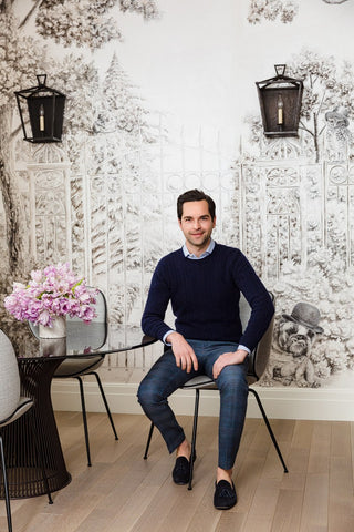 Leifer at the apartment's dining table, with a de Gournay wall panel as a backdrop.