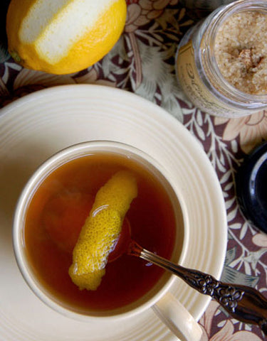 Tea cup of Candy Cap Hot Bourbon garnished with lemon peel and made with Wine Forest Wild Foods Candy Cap Sugar