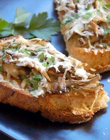 Slices of Maitake Pizzetta with melting parmesan cheese on top