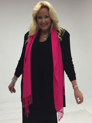 black outfit with hot pink scarf worn draped around the neck