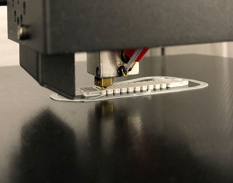 Printing a one-way spring out of polycarbonate to precisely constrain motion of the carriage.