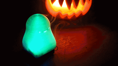 Looping video of a translucent plastic ghost internally illuminated with a pulsing light changing between green and blue