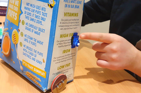 Image of a blue servo attached to the side of a cereal box