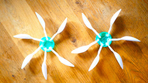 Image of two propellers, which are made from green milk bottle lids and plastic spoons.