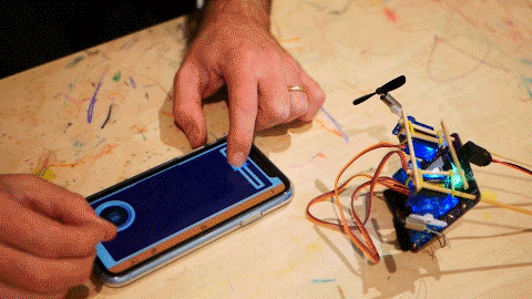 GIF of a robot with two propellers being controlled by a smartphone app.