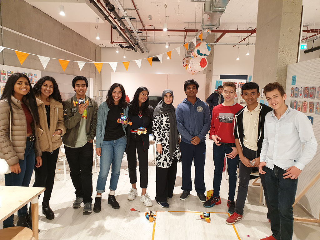 An image of 10 individuals standing and looking towards the camera, smiling